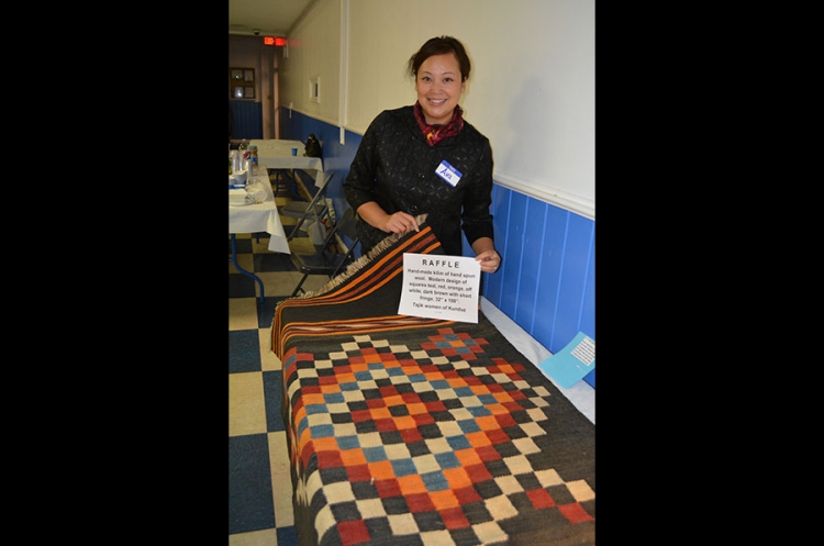 Raffle winner displays her prize kilim at the 2017 Kabultec Benefit Dinner.